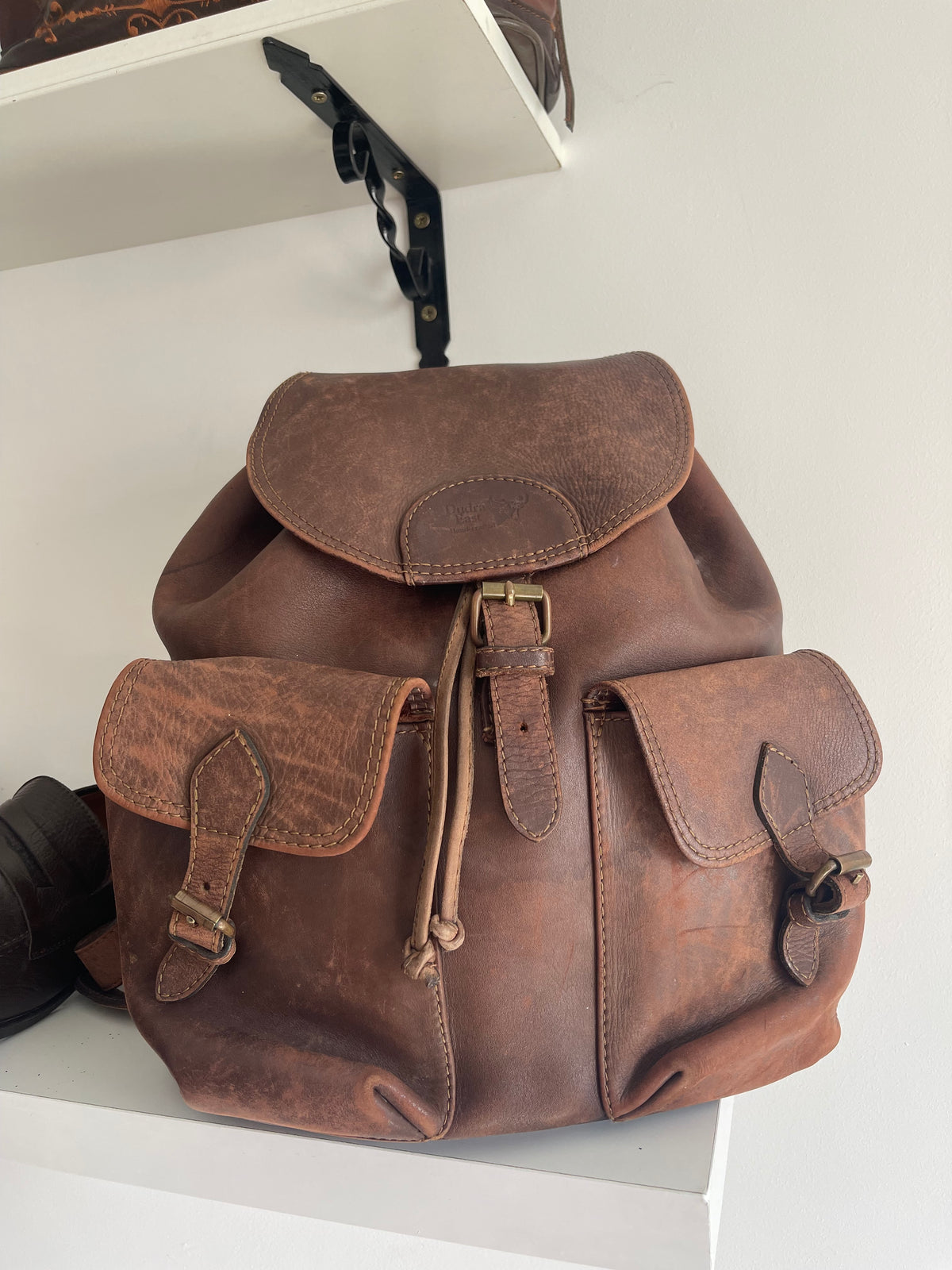 Sac à dos en cuir marron vintage, style baroudeur à rabat et poches boucles