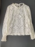 Blouse en dentelle écrue à col volanté