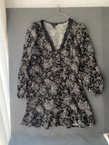 Robe noire à petites fleurs et col V en dentelle