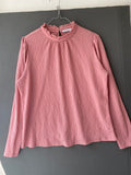 Blouse rose texturée à col volanté