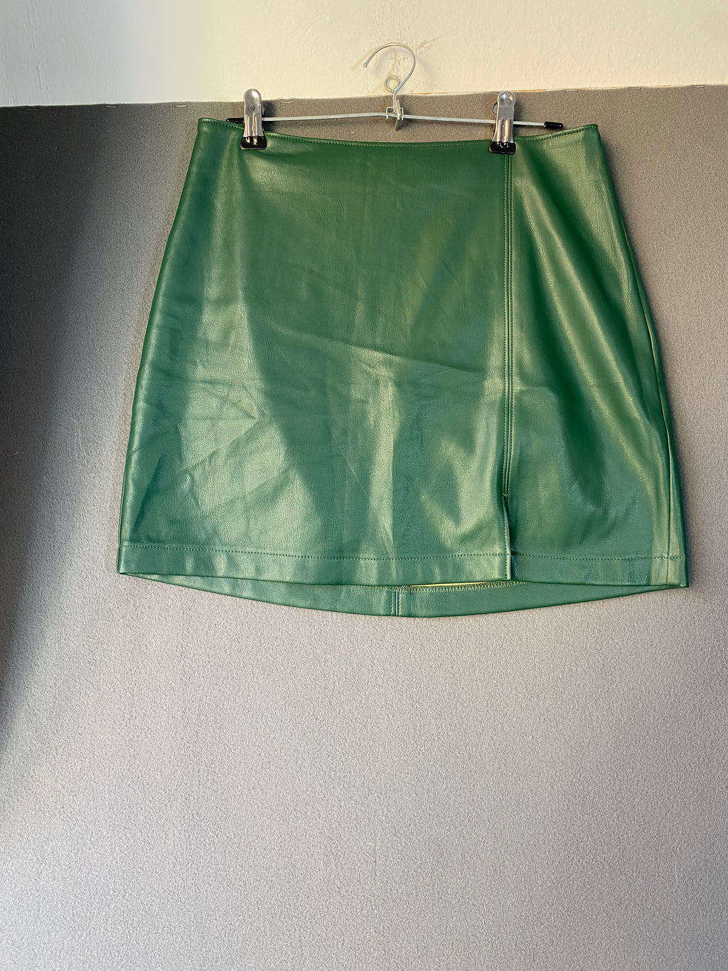 Mini-jupe en simili cuir vert sapin à fente