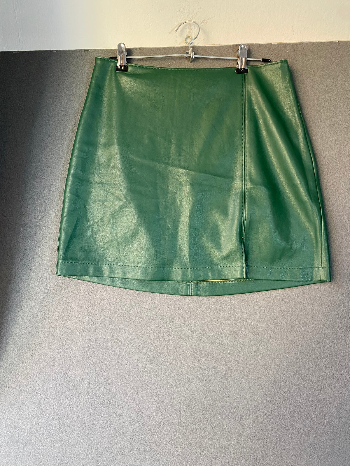 Mini-jupe en simili cuir vert sapin à fente