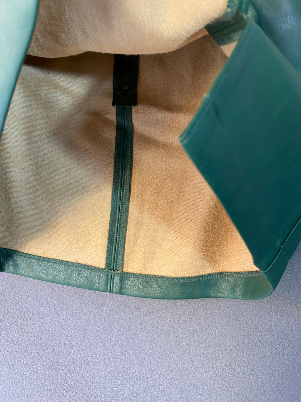 Mini-jupe en simili cuir vert sapin à fente