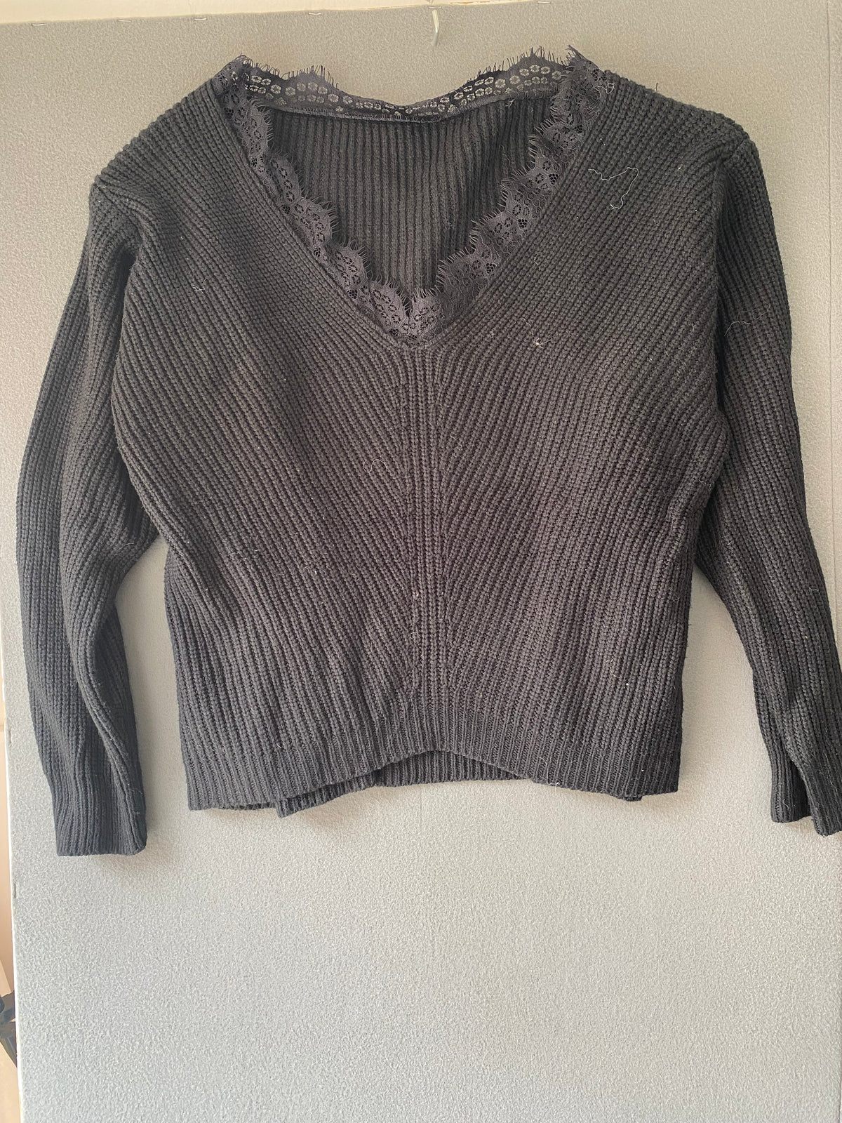 Pull noir col V bordé de dentelle