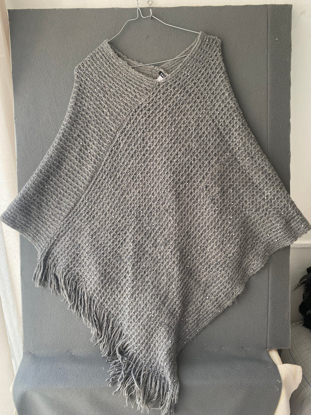 Poncho en maille grise à sequins et franges