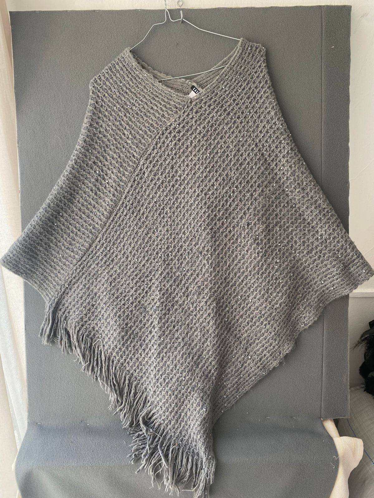 Poncho en maille grise à sequins et franges