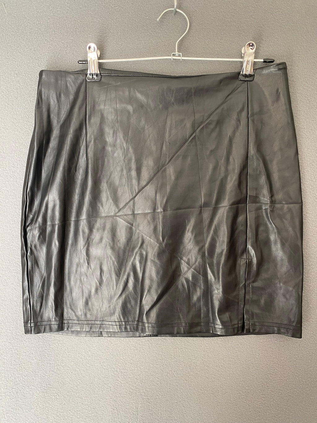 Mini-jupe en simili cuir noire à fente