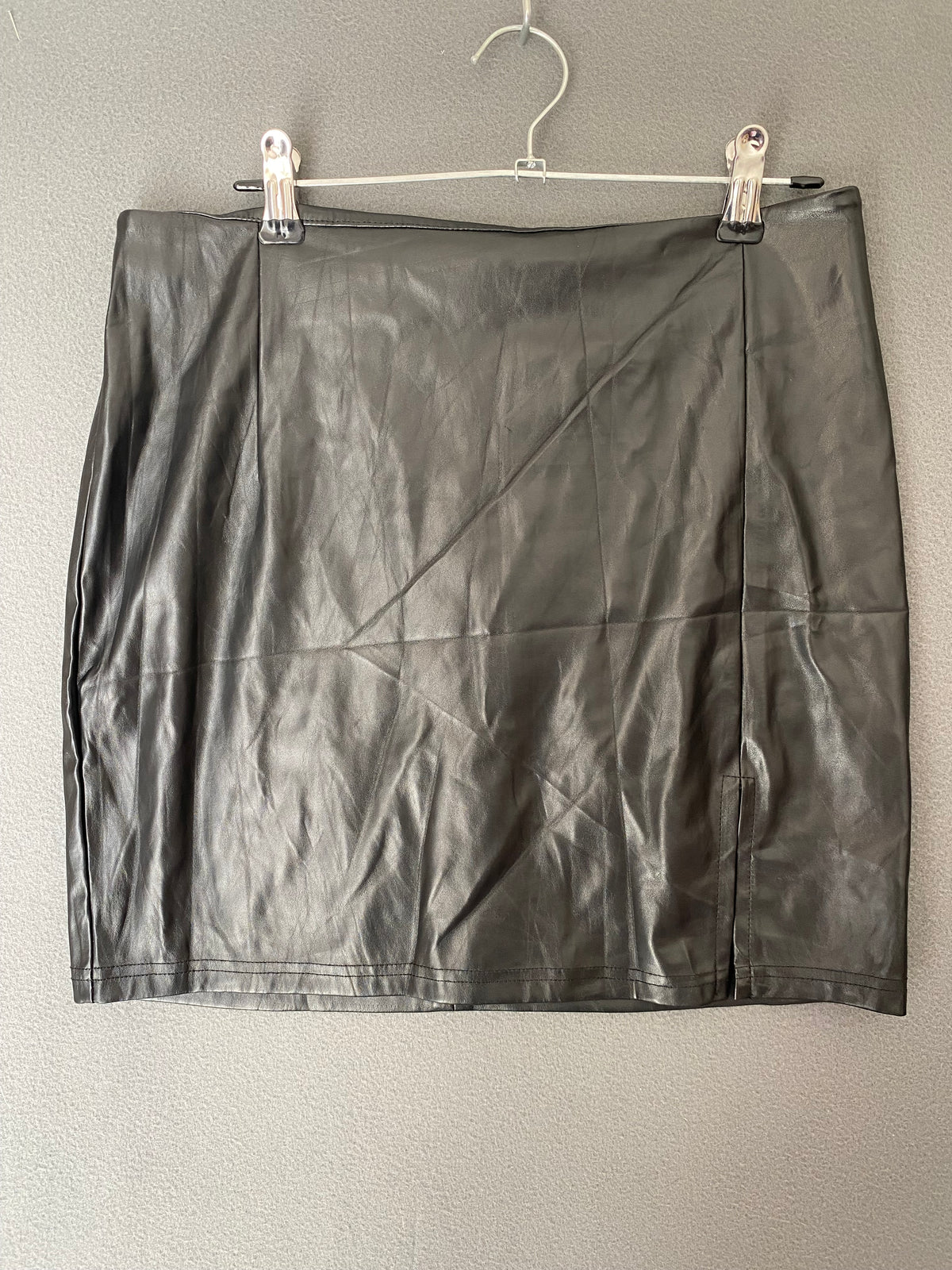 Mini-jupe en simili cuir noire à fente