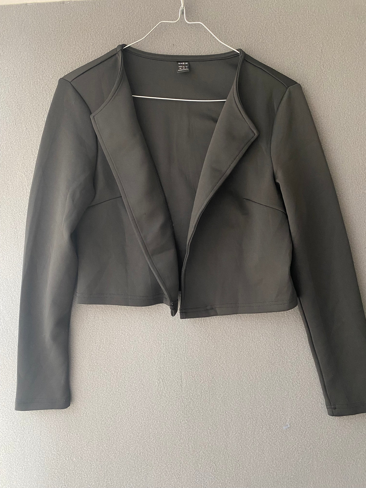 Veste courte noire ouverte à col revers