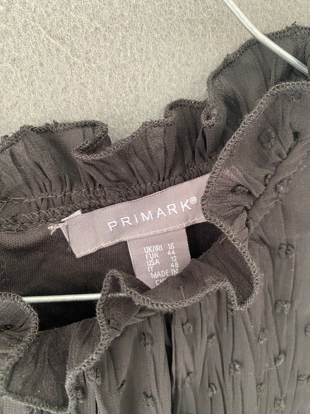 Robe noire en plumetis à col volanté