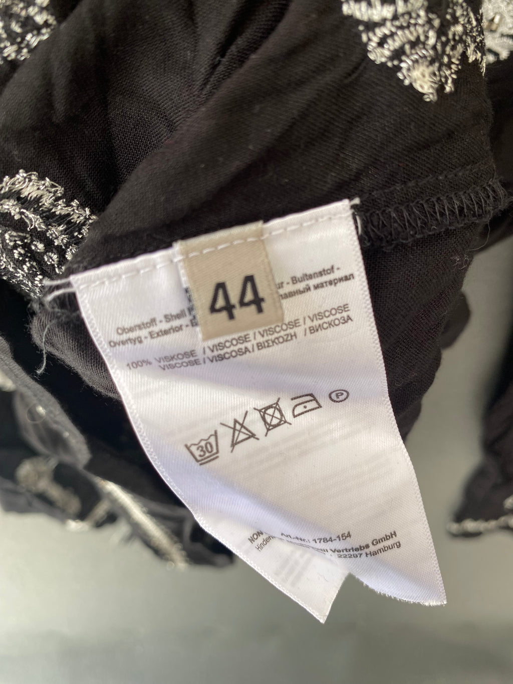Blouse noire brodée argent à pompons