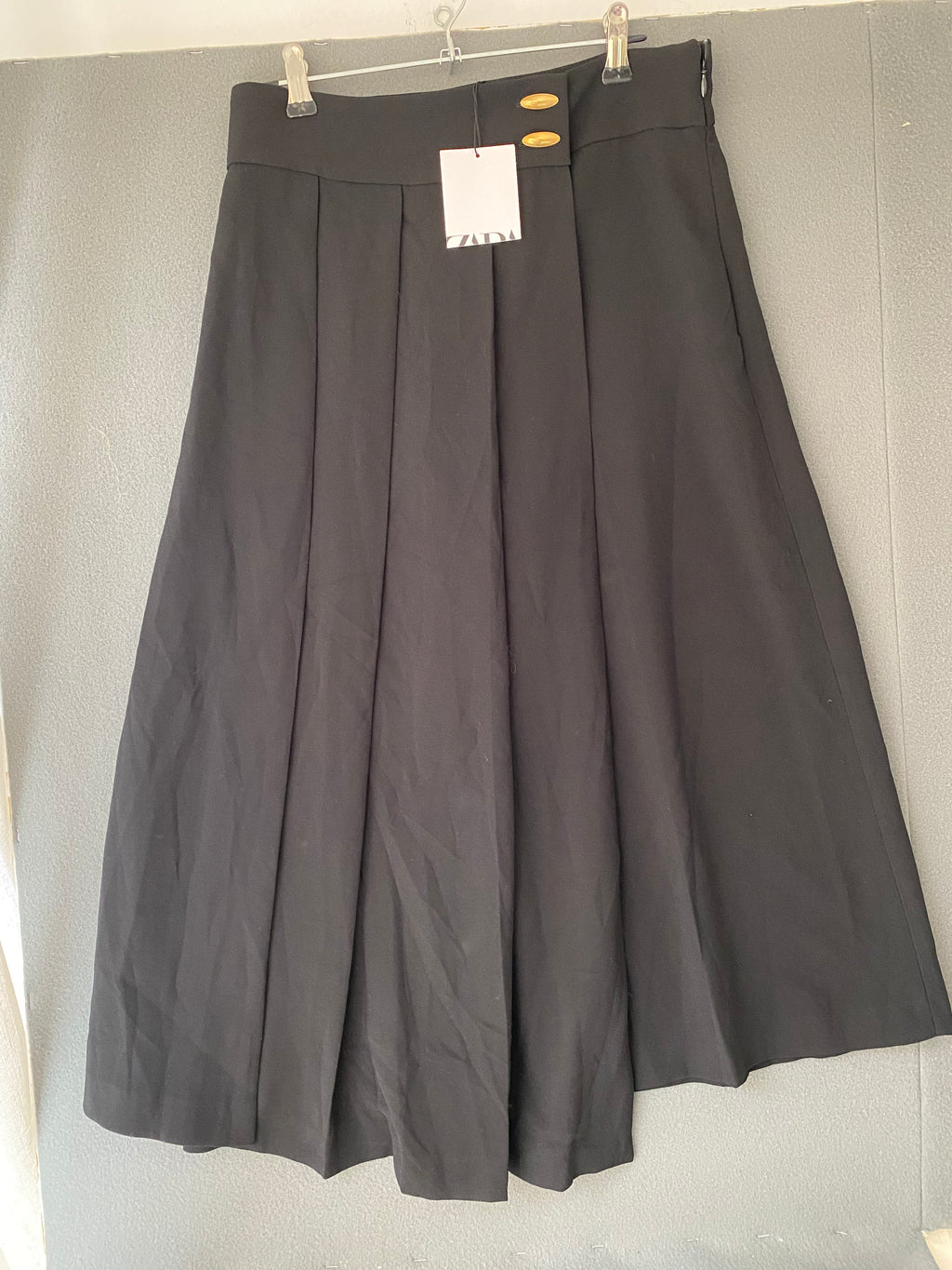 Jupe short midi plissée asymétrique noire à boutons dorés