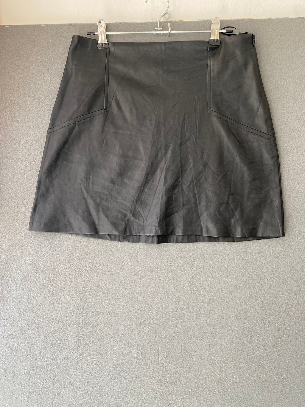 Mini-jupe en simili cuir noire à découpes