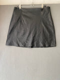 Mini-jupe en simili cuir noire à découpes