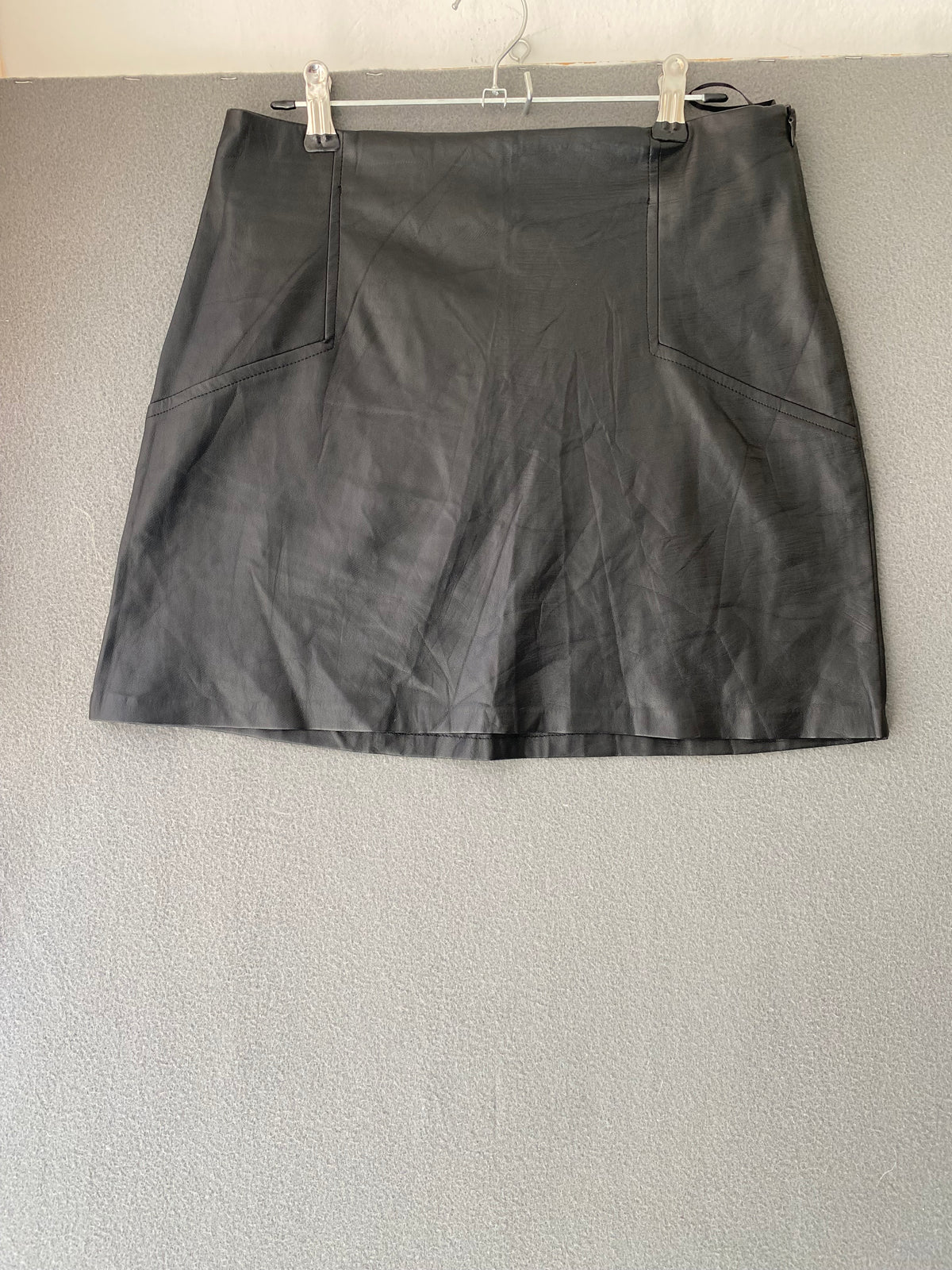 Mini-jupe en simili cuir noire à découpes